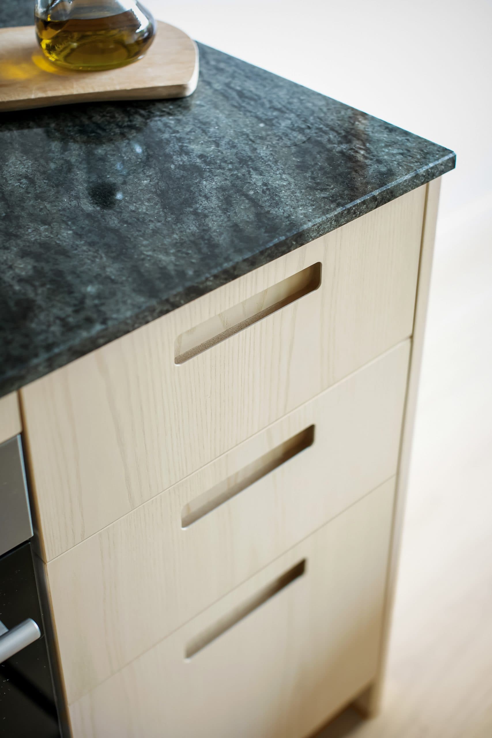 Ask kök med mörk bänkskiva